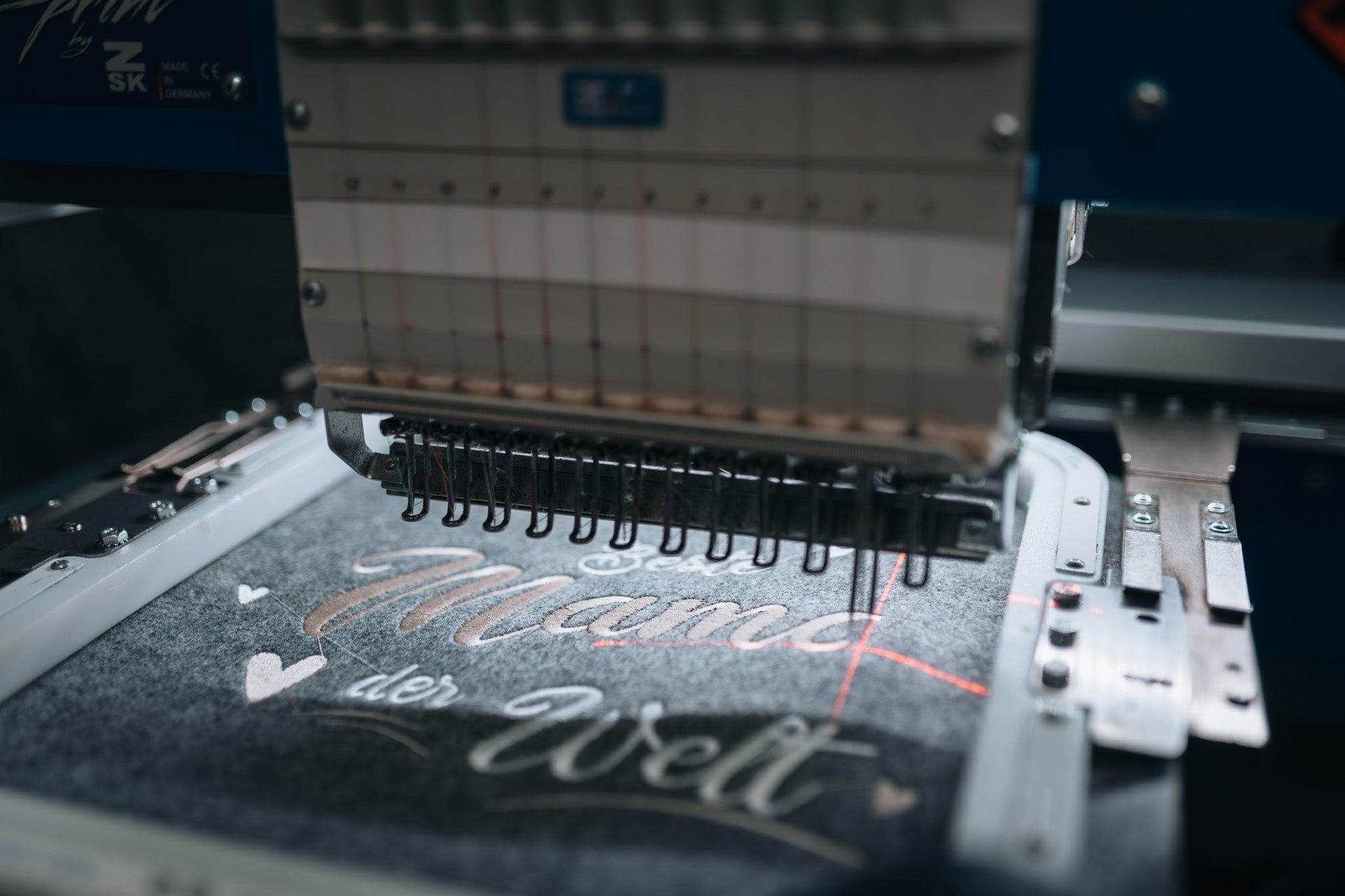 Stickmaschine bestickt einen personalisierten Schriftzug in Echtzeit – Made in Austria